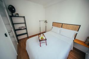 a bedroom with a large white bed with a table at Apartamento confortável próximo ao Transamérica Expo in São Paulo