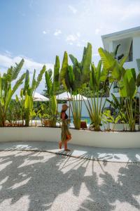 a woman walking in front of a building with plants at Sky House Santa Teresa - Adults only in Santa Teresa Beach