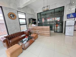 ein Wohnzimmer mit Sofa und Tisch in der Unterkunft SC Residences in Surat Thani