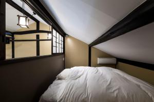 ein Schlafzimmer mit einem weißen Bett und einem Fenster in der Unterkunft NEOLD Private House in Yoshino