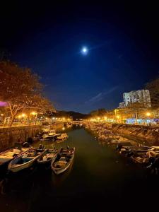 a group of boats docked in a river at night at A private room in beachside bungalow for women only in Hong Kong