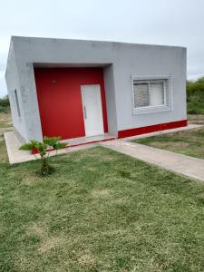una casa roja y blanca con garaje rojo en casa pileta patio indio froilan estadio unico madre de ciudades en Santiago del Estero
