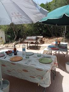 a table with an umbrella and two tables with drinks at Villa Celeste in Rena Majore
