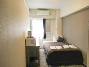 Postel nebo postele na pokoji v ubytování HOTEL LiVEMAX BUDGET Kawasaki Ekimae