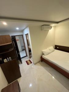 um pequeno quarto com uma cama e um espelho em Khách sạn Thiên Minh - Dốc Lết em My Luong