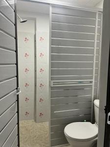 a small bathroom with a toilet and a shower at hostal la niña carmen in Cartagena de Indias