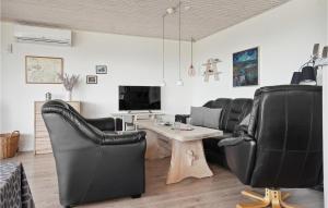 a living room with black leather chairs and a table at Amazing Home In Snedsted With 4 Bedrooms, Sauna And Wifi in Skyum