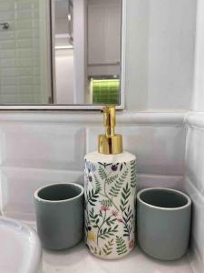 a bathroom sink with a bottle and two cups at Loving family in Phu Quoc +18 photos