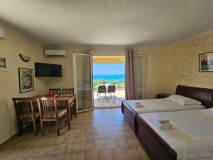 Pokój hotelowy z 2 łóżkami i stołem oraz balkonem w obiekcie Corfu Glyfada Apartment 45 w mieście Glifada
