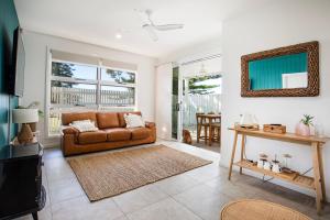 uma sala de estar com um sofá e uma mesa em LegaSea Lodge - Pet Friendly Beachfront with Plunge Pool em Shellharbour