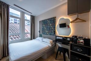 um pequeno quarto com uma cama e uma janela em Fragrance Hotel - Oasis em Singapura