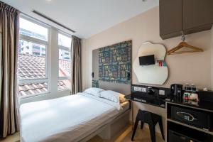 a small bedroom with a bed and a window at Fragrance Hotel - Oasis in Singapore