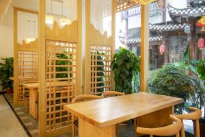 une salle à manger avec des tables et des chaises en bois dans l'établissement 武陵山水客栈Wuling Shanshui Hotel, à Zhangjiajie