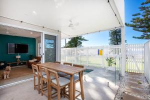 a dining room with a table and chairs on a balcony at LegaSea Lodge - Pet Friendly Beachfront with Plunge Pool in Shellharbour
