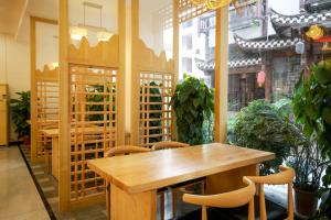 a wooden table and chairs in a room with plants at 武陵山水客栈Wuling Shanshui Hotel in Zhangjiajie