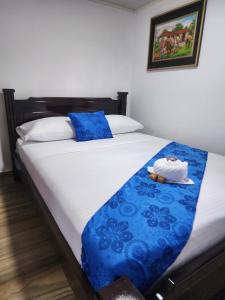 - une chambre dotée d'un lit avec des draps bleus et blancs dans l'établissement Finca Hotel Las Palmeras, à Armenia