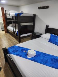 - une chambre avec 2 lits avec des draps bleus et blancs dans l'établissement Finca Hotel Las Palmeras, à Armenia