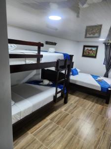 Cette chambre comprend 2 lits superposés et du parquet. dans l'établissement Finca Hotel Las Palmeras, à Armenia