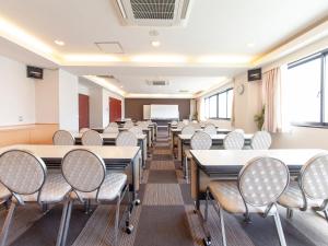 una classe con file di tavoli e sedie di HOTEL LiVEMAX BUDGET Sagamihara a Sagamihara