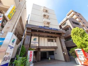 un edificio con un cartel de hotel en vivo en HOTEL LiVEMAX BUDGET Sagamihara, en Sagamihara