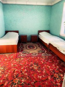 two beds in a room with a red carpet at CBT1 Sary-mogul in Sary-Mogul