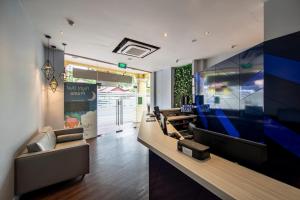 a lobby with couches and a large flat screen tv at Fragrance Hotel - Classic in Singapore