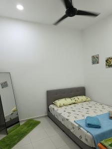 Schlafzimmer mit einem Bett und einem Deckenventilator in der Unterkunft D'Nenas Homestay Kijal in Kijal