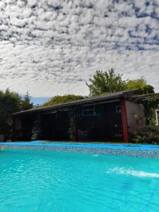 una casa con piscina al lado de un edificio en Departamentos Las Marias en Villa Cura Brochero