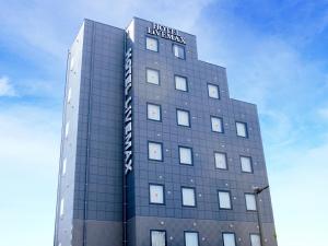 a building with a sign on the top of it at HOTEL LiVEMAX Sagamihara Ekimae in Sagamihara