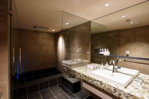 uma casa de banho com um lavatório, um chuveiro e um espelho. em hotori em Quioto