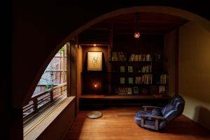 ein Wohnzimmer mit einem Fenster und einem Bücherregal in der Unterkunft hotori in Kyoto