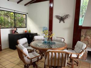 a dining room with a table and chairs and a butterfly on the wall at Cabaña Vistas del Volcán in Nueva San Salvador