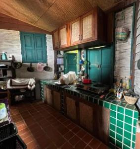 une cuisine avec des placards bleus et un comptoir vert dans l'établissement The Lookout Pai, à Pai