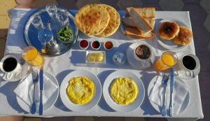 a table with plates of breakfast food on it at Riad Le Grand Large in Essaouira