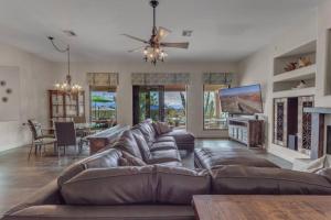 uma sala de estar com um sofá de couro castanho e uma televisão em Serene Resort Style Living w/ Dream Backyard em Scottsdale