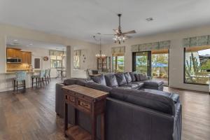 a living room with a leather couch and a kitchen at Desert Retreat with Dream Backyard in Scottsdale