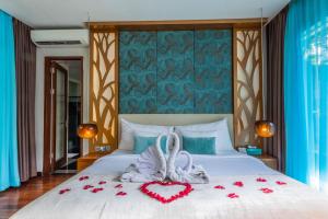 um quarto com uma cama com um coração feito de rosas em The Leaf Jimbaran Luxury Villas em Jimbaran