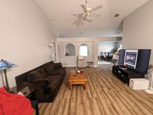 a living room with a couch and a tv at 2 private rooms in a quiet neighborhood can book up to 4 people in Orlando