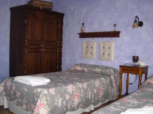 1 dormitorio con 2 camas y armario de madera en Agroturismo "La Bardena Blanca II", en Arguedas