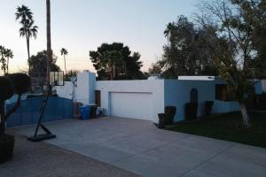 a white house with a driveway and a garage at Moon Valley Treasure - Chef's Kitchen l Pool l Spa in Phoenix