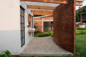 une passerelle en briques menant à une maison avec évier dans l'établissement Las Orquídeas, à Tepoztlán