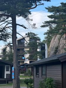 un bâtiment avec un arbre en face d'une montagne dans l'établissement Årossanden feriesenter, Søgne, Kristiansand, à Kristiansand