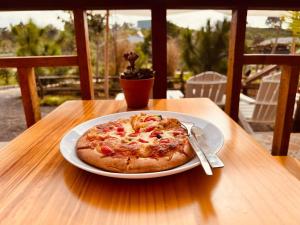 uma pizza sentada num prato numa mesa em Eliss Garden Coffee & Homestay em Ấp Thiện Lập