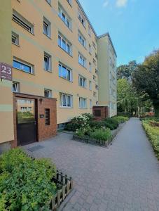 a building with a walkway in front of a building at INITIUM rooms - Apartament - Tysiąclecia 23B in Gdańsk