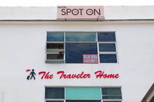 a sign for the traveler home on the side of a building at SPOT ON 89805 The Traveler Home in Sibu