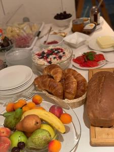 - une table avec des assiettes de nourriture, des viennoiseries et du pain dans l'établissement Gasthof Hirschen, à Oey