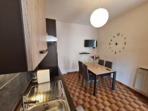 eine Küche mit einem Tisch mit Stühlen und einer Uhr an der Wand in der Unterkunft La casa del Gigante Frassino in Acceglio