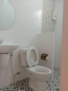 La salle de bains blanche est pourvue de toilettes et d'un lavabo. dans l'établissement บ้านชมดาวรีสอร์ทบึงโขงหลง, à Ban Don Klang