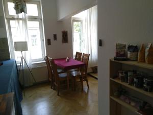 Schönes Jugendstil Appartement in bester Lage في لايبزيغ: غرفة طعام مع طاولة وكراسي أرجوانية
