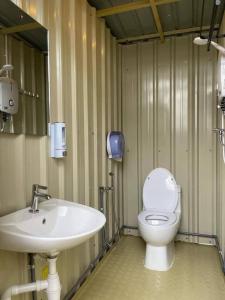 a bathroom with a white toilet and a sink at iGo Glamz 爱狗露营 Pet Friendly Glamping in Genting Highlands